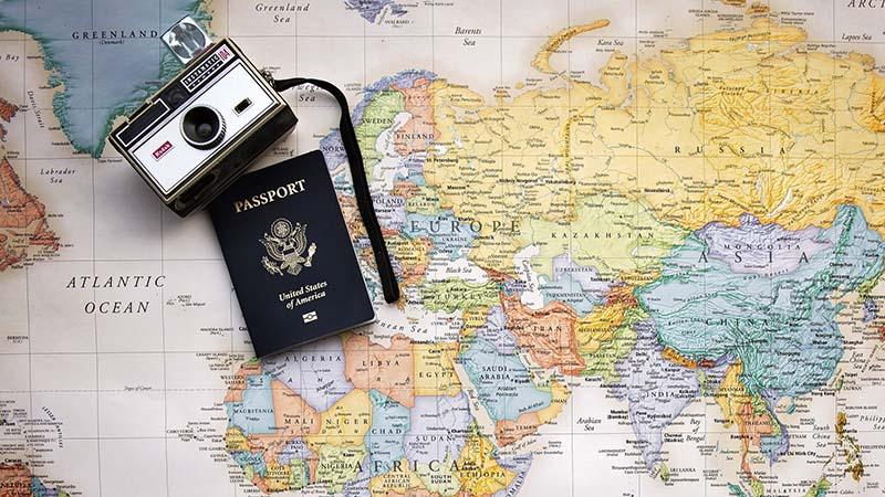 U.S. passport, old camera and world map 